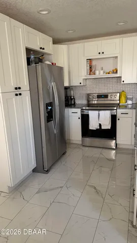 a kitchen with refrigerator and cabinets