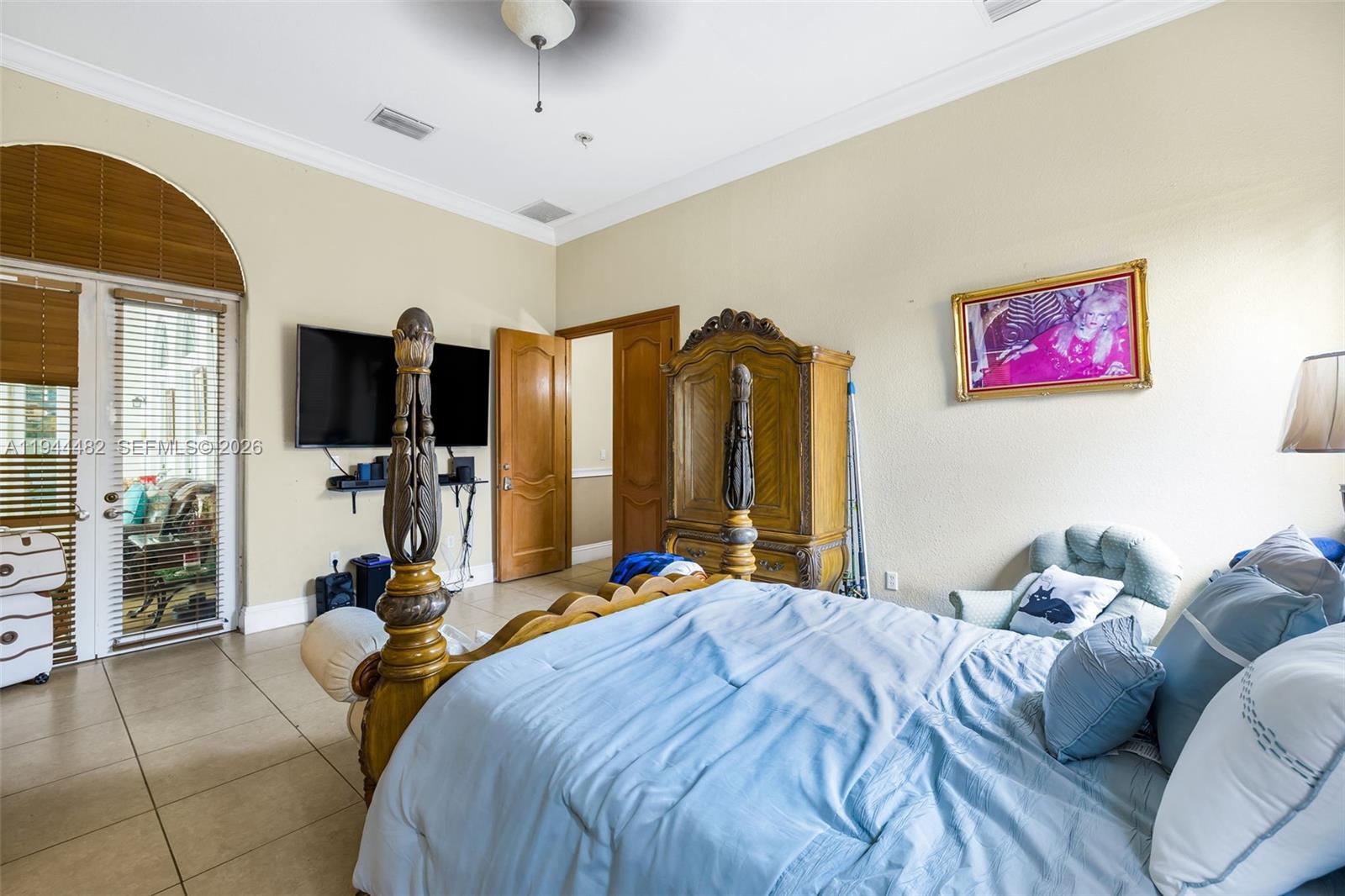 7761 Southwest 122nd Avenue Miami, FL 33183 - Photo 27 of 54 a bedroom with a bed flat screen tv and a large window