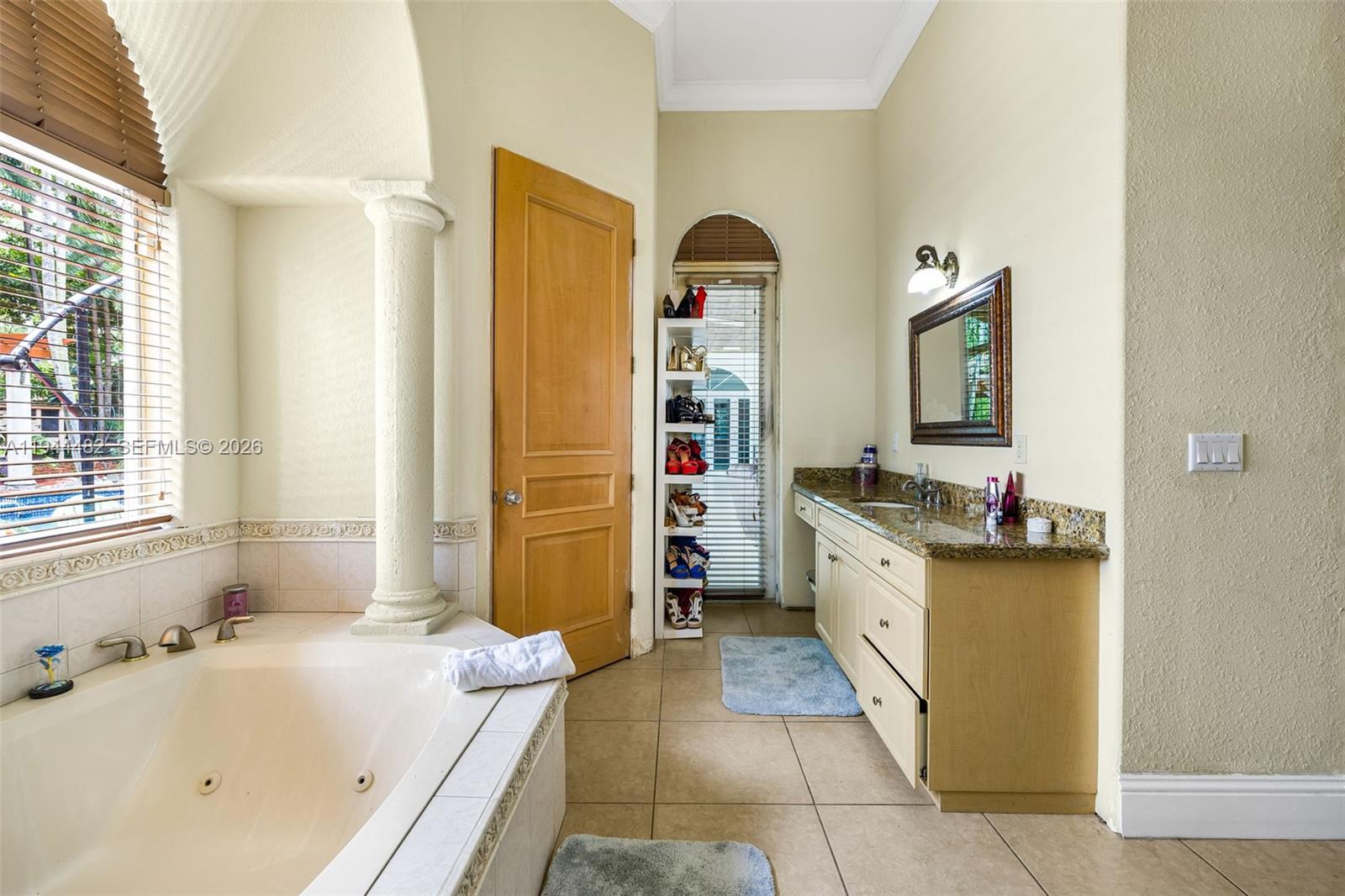 7761 Southwest 122nd Avenue Miami, FL 33183 - Photo 30 of 54 a bathroom with a tub sink and mirror