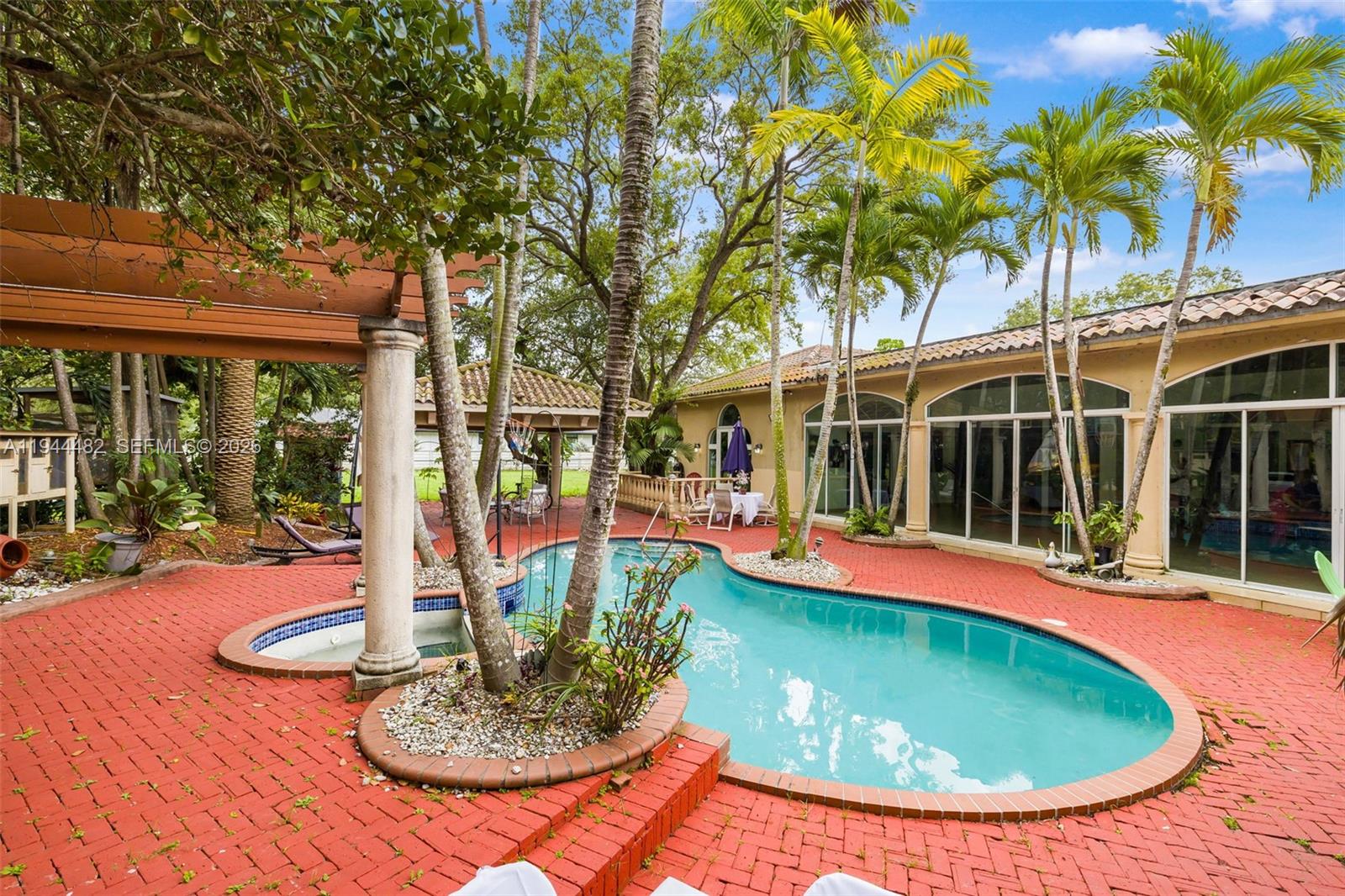 7761 Southwest 122nd Avenue Miami, FL 33183 - Photo 36 of 54 a view of a swimming pool with an outdoor space and seating area