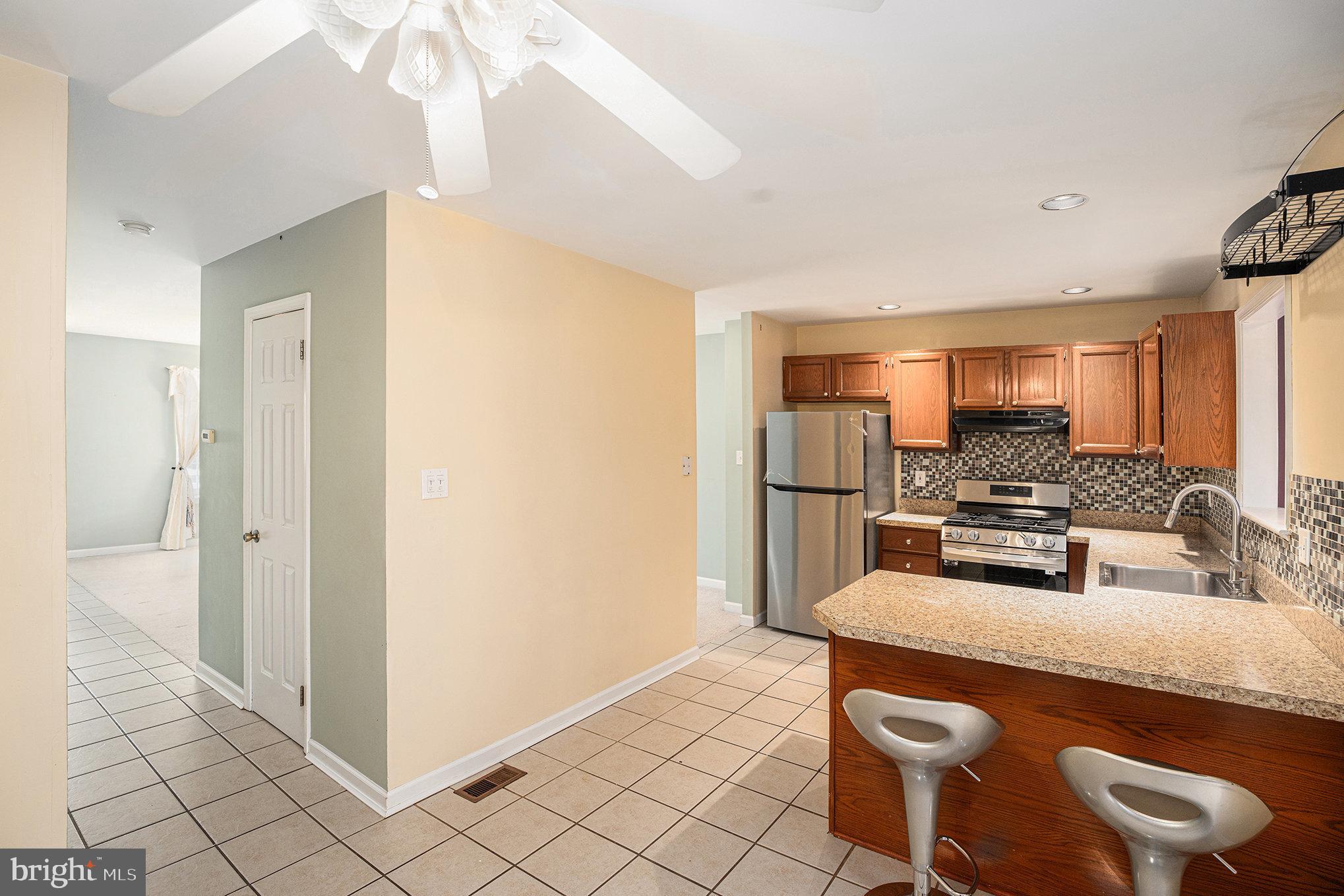 1042 Rafter Road Eagleville, PA 19403 - Photo 7 of 26 a kitchen with a refrigerator and a stove top oven