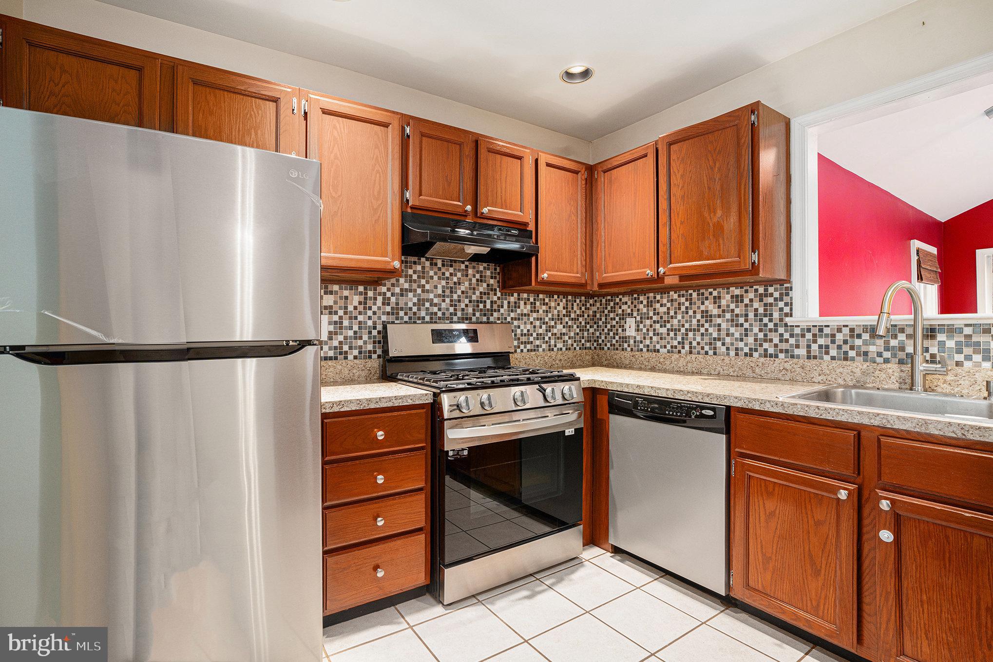 1042 Rafter Road Eagleville, PA 19403 - Photo 8 of 26 a kitchen with granite countertop a refrigerator stove top oven and sink