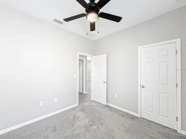 an empty room with window and ceiling fan