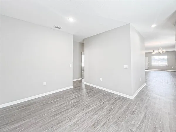 a view of an empty room with wooden floor