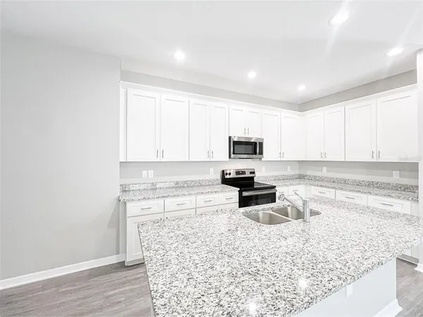 a kitchen with a stove a sink and a microwave