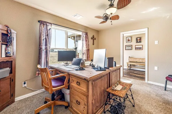 a view of a workspace with furniture and a window
