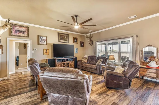 a living room with furniture a flat screen tv and a floor to ceiling window