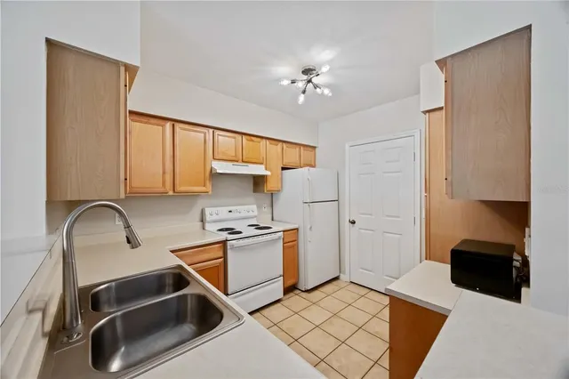 a kitchen with stainless steel appliances a stove a sink and a refrigerator with wooden floor