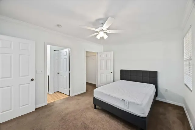 a bedroom with a bed and a ceiling fan