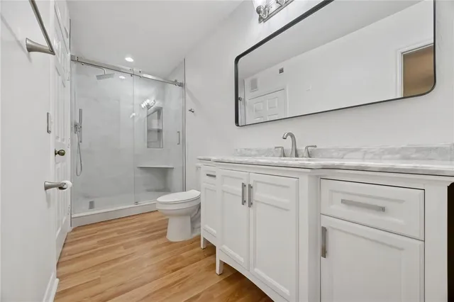 a bathroom with a granite countertop sink toilet a shower and a mirror
