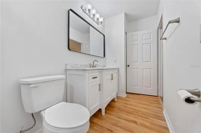 a bathroom with a toilet a sink a mirror a vanity and shower