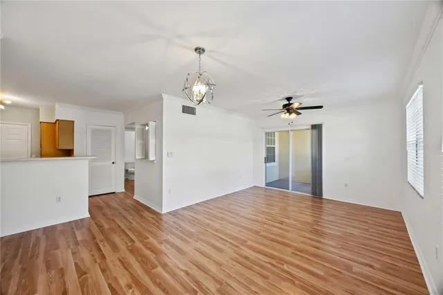 a view of a room with wooden floor and chandelier