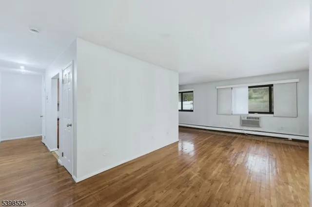 a view of a room with wooden floor and window