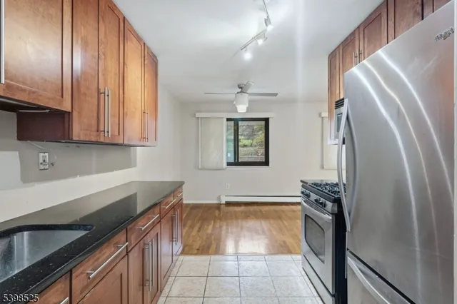 a kitchen with granite countertop a refrigerator and a sink