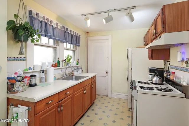 a kitchen with stainless steel appliances a sink a refrigerator and a counter space