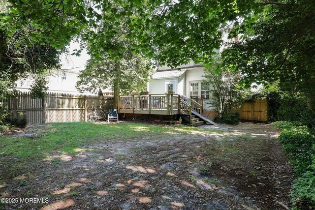 a view of a house with backyard and a tree