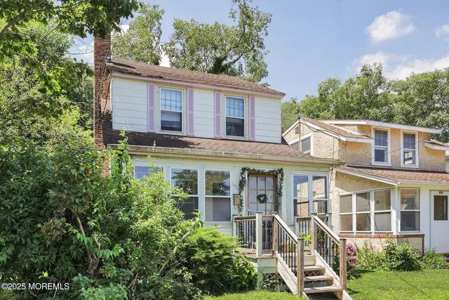 a view of a house with a yard and potted plants