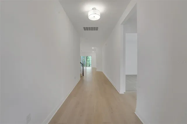 a view of a hallway with wooden floor