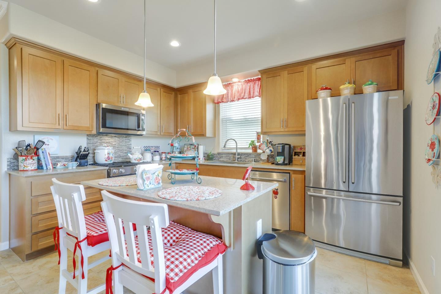260 Springtime Circle Hollister, CA 95023 - Photo 11 of 46 a kitchen with stainless steel appliances granite countertop a refrigerator a stove a sink dishwasher and white cabinets with wooden floor