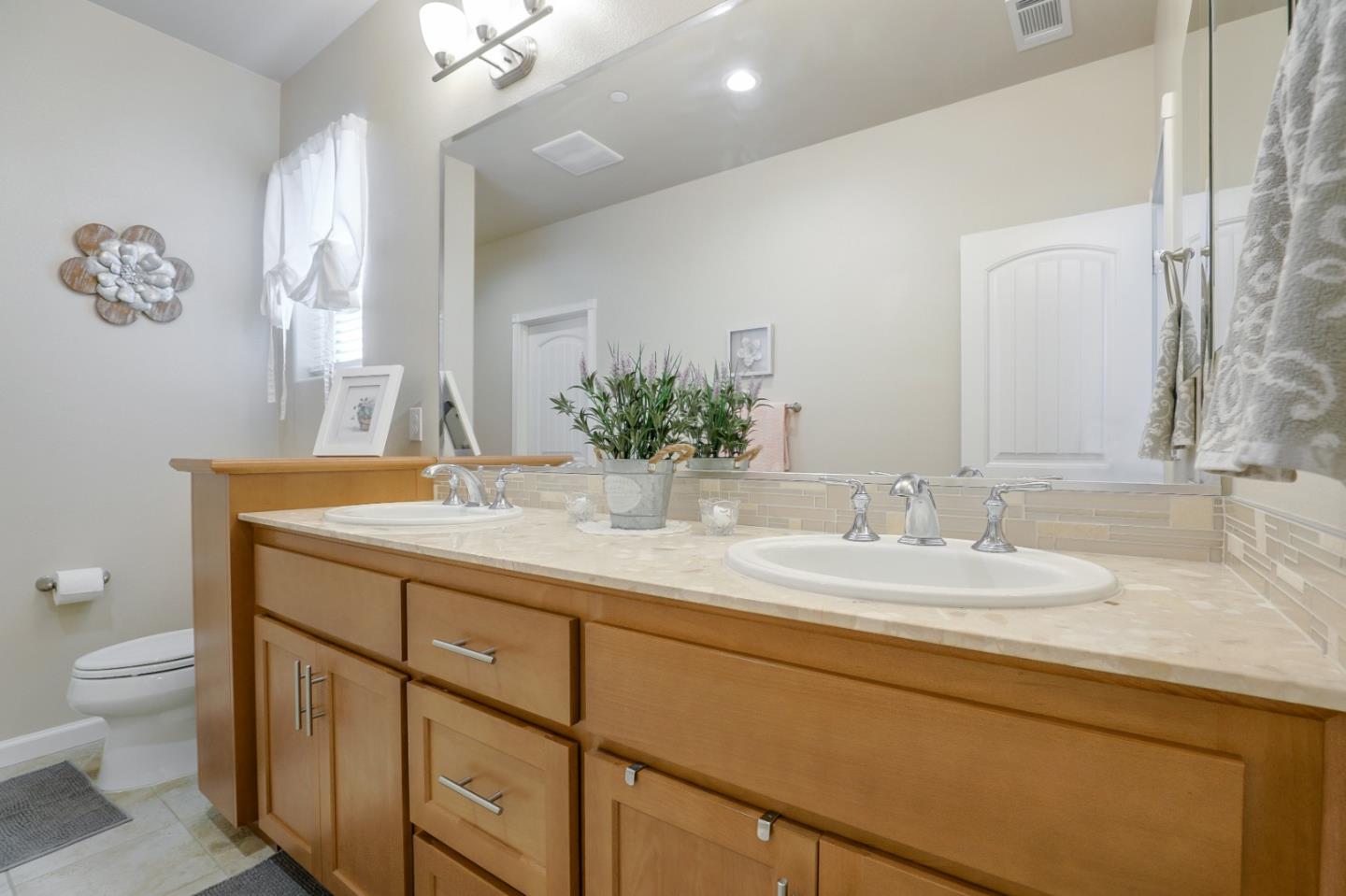 260 Springtime Circle Hollister, CA 95023 - Photo 39 of 46 a bathroom with a granite countertop sink a toilet and a large mirror