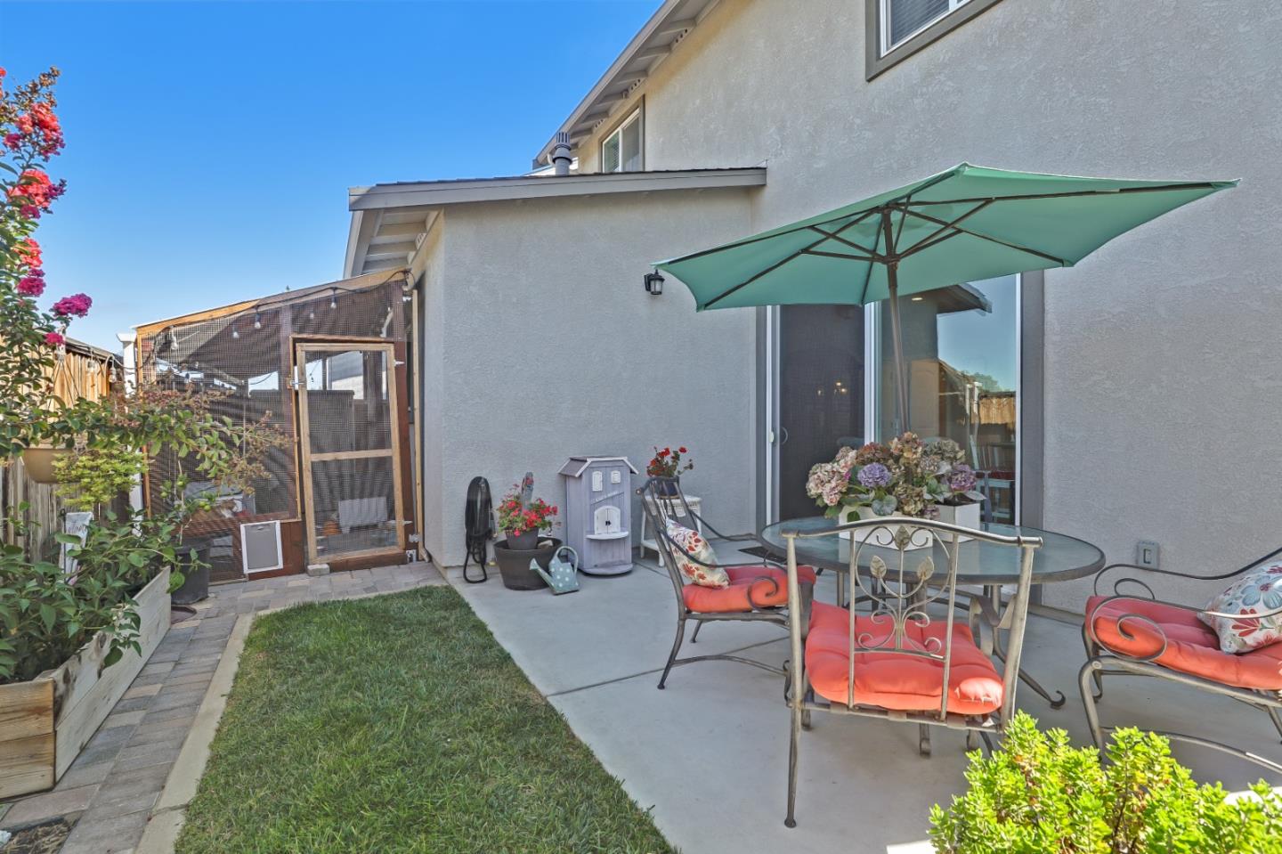 260 Springtime Circle Hollister, CA 95023 - Photo 44 of 46 a backyard of a house with table and chairs under an umbrella