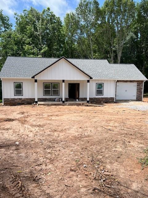 a front view of house with yard and trees in the background