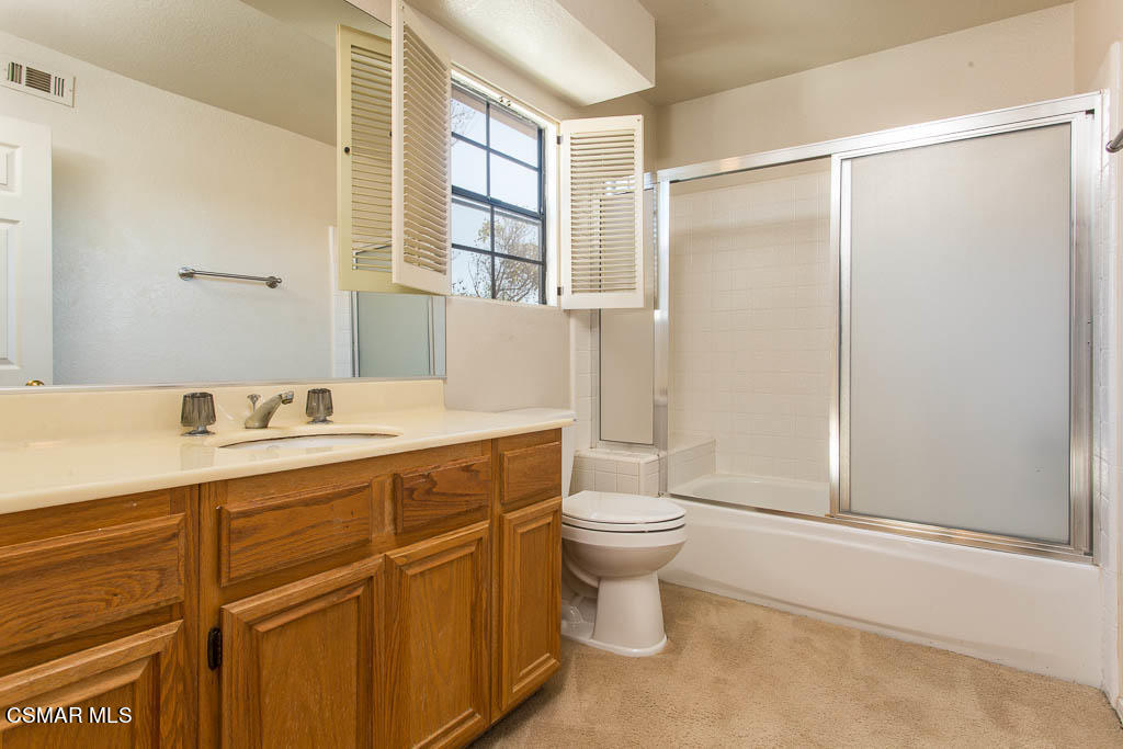 753 Congressional Road Simi Valley, CA 93065 - Photo 16 of 37 a bathroom with a granite countertop sink toilet a mirror and shower