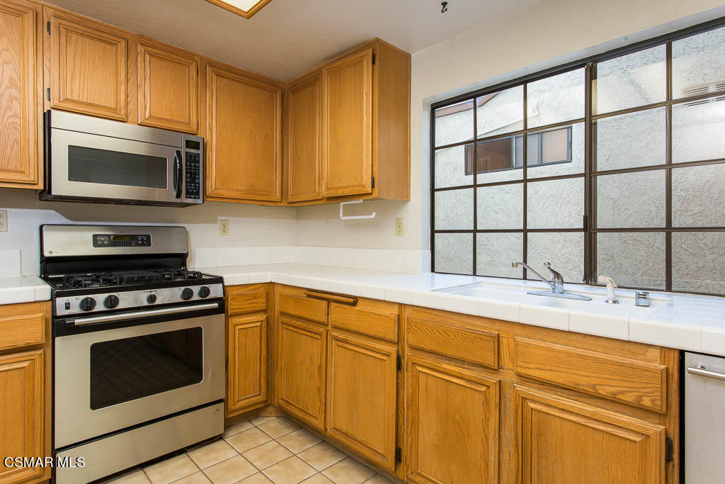 753 Congressional Road Simi Valley, CA 93065 - Photo 7 of 37 a kitchen with stainless steel appliances granite countertop a stove microwave and cabinets