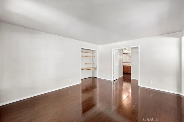 a view of an empty room with wooden floor