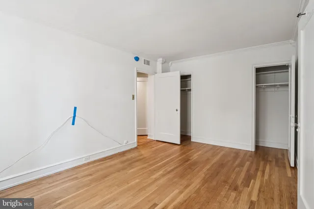 a view of empty room with wooden floor