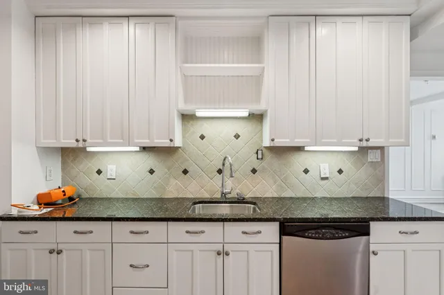 a kitchen with granite countertop white cabinets and white appliances
