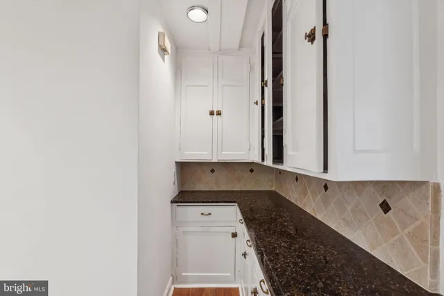 a kitchen with granite countertop white cabinets and black appliances