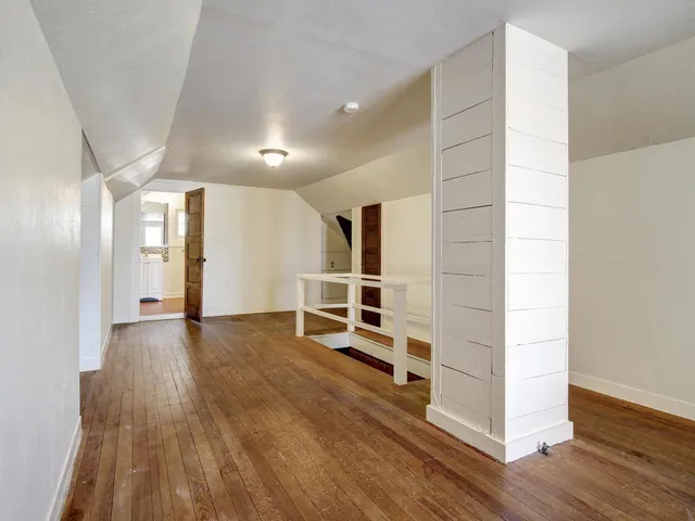 a view of a room with wooden floor and window