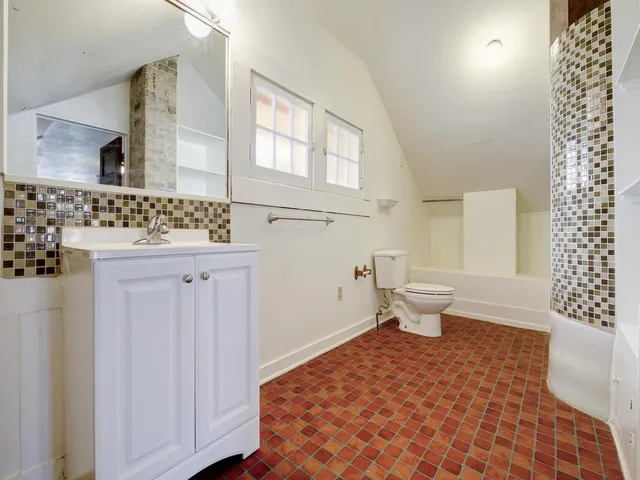 a bathroom with a sink toilet and window