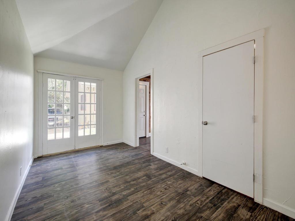 903 Shoal Cliff Court Austin, TX 78705 - Photo 27 of 32 a view of an empty room with wooden floor and a window