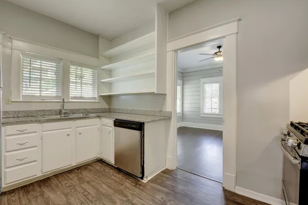 a kitchen with granite countertop white cabinets and white appliances
