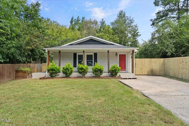 a front view of a house with yard and green space
