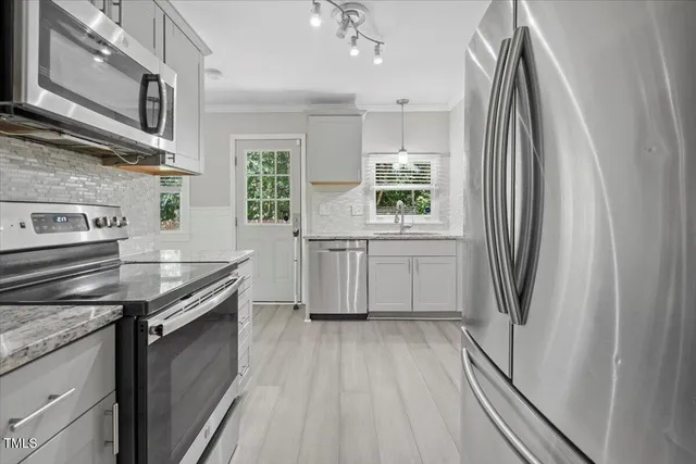 a kitchen with stainless steel appliances granite countertop a refrigerator and a stove
