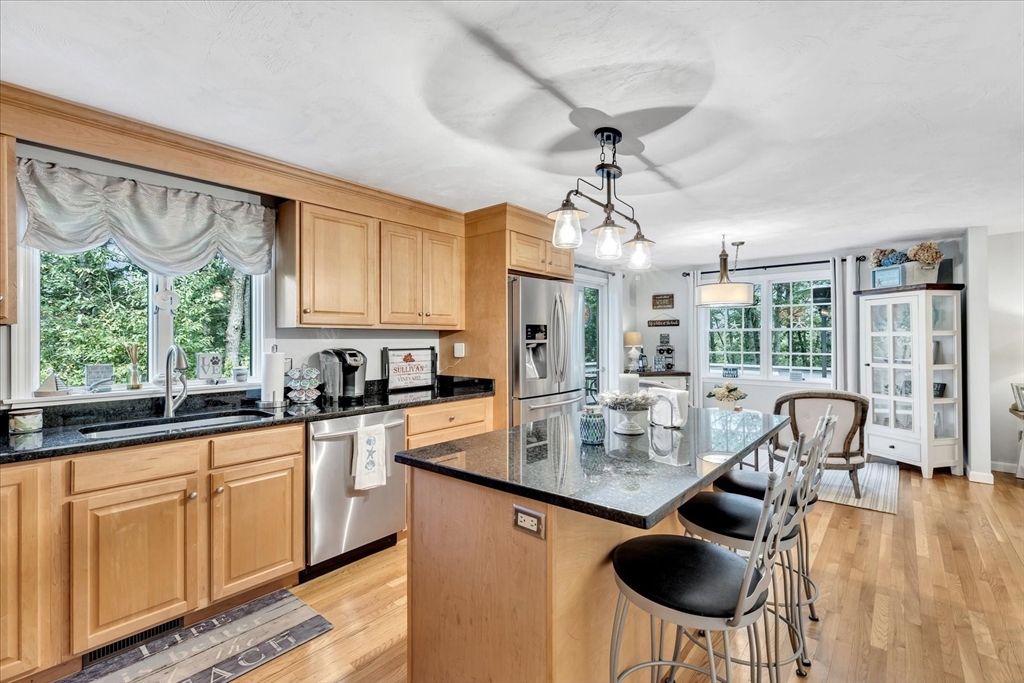17 Wellfield Road Sandwich, MA 02644 - Photo 5 of 39 a kitchen with stainless steel appliances granite countertop a stove a sink dishwasher and white cabinets with wooden floor