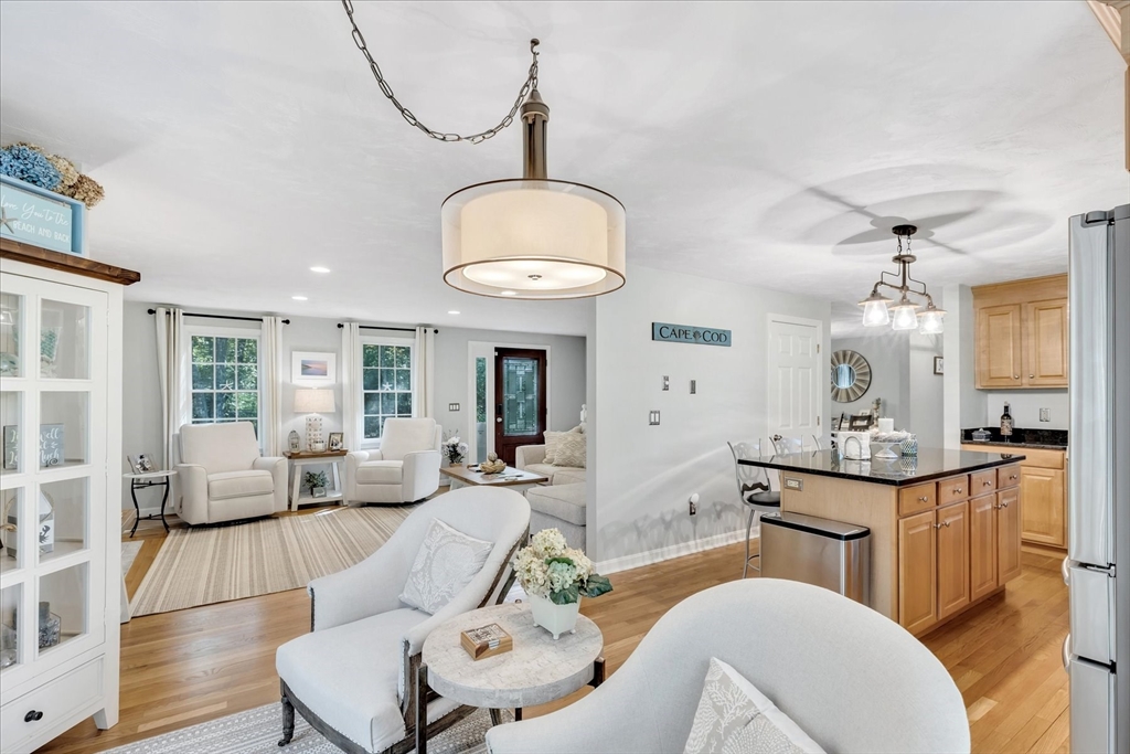 17 Wellfield Road Sandwich, MA 02644 - Photo 10 of 39 a living room with kitchen island furniture and a chandelier