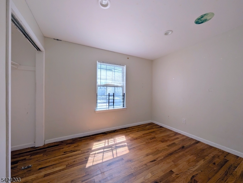 448 Fulton Street Elizabeth Port, NJ 07206 - Photo 13 of 37 a view of an empty room with wooden floor and a window