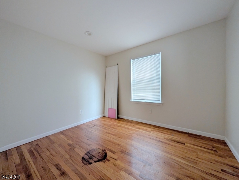 448 Fulton Street Elizabeth Port, NJ 07206 - Photo 14 of 37 a view of an empty room with wooden floor and a window