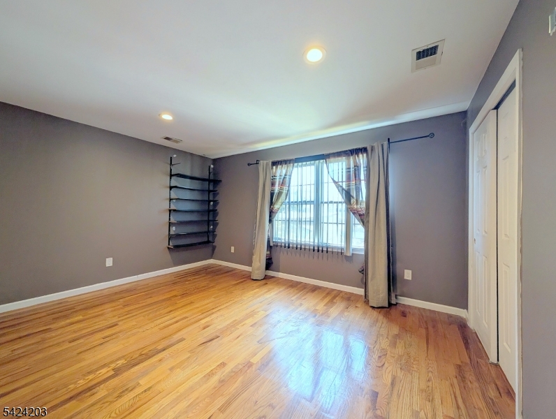 448 Fulton Street Elizabeth Port, NJ 07206 - Photo 22 of 37 a view of an empty room with a window and wooden floor