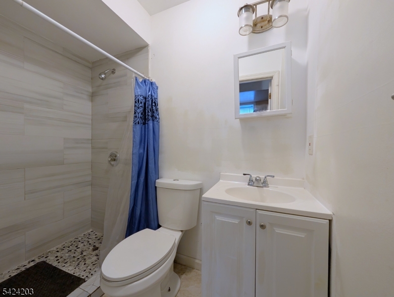 448 Fulton Street Elizabeth Port, NJ 07206 - Photo 32 of 37 a white toilet sitting next to a bathroom sink