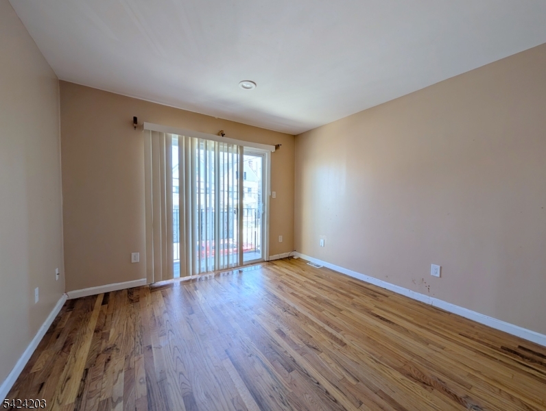 448 Fulton Street Elizabeth Port, NJ 07206 - Photo 4 of 37 a view of an empty room with wooden floor and a window