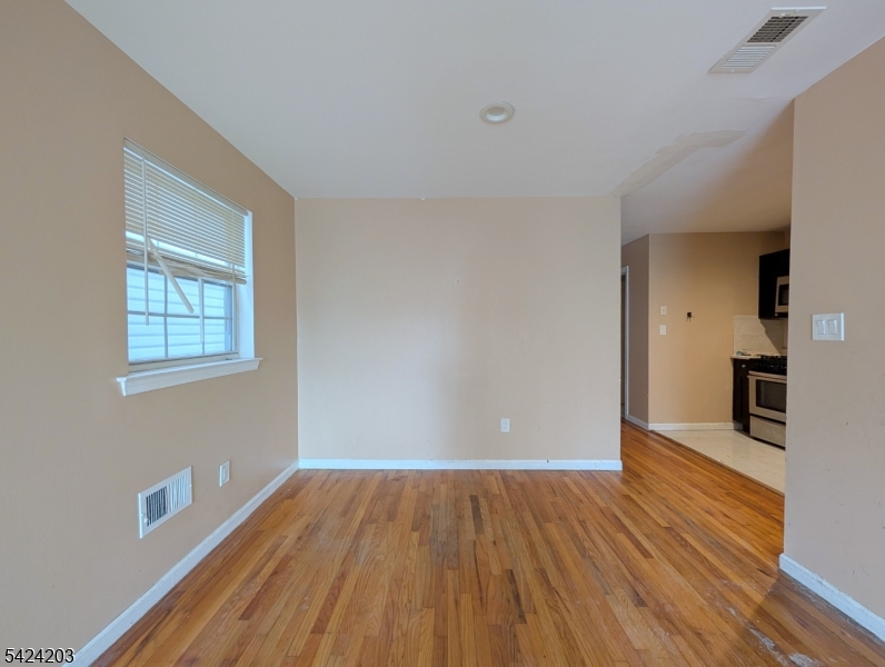 448 Fulton Street Elizabeth Port, NJ 07206 - Photo 5 of 37 wooden floor in an empty room with a window