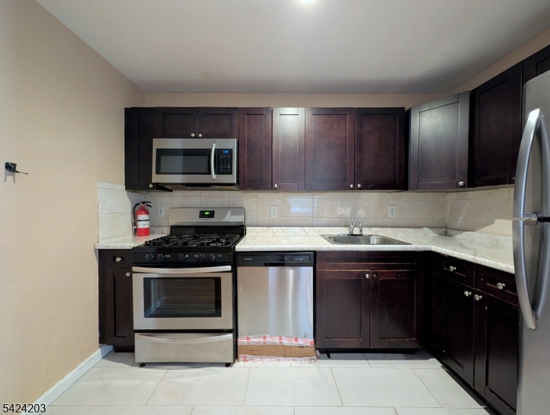 448 Fulton Street Elizabeth Port, NJ 07206 - Photo 6 of 37 a kitchen with stainless steel appliances granite countertop a stove and a microwave