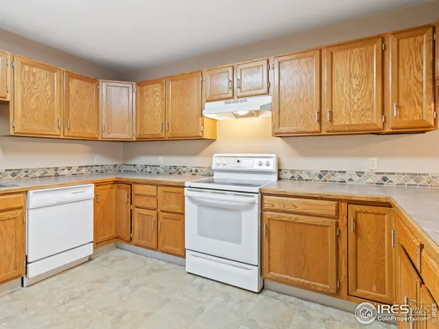 a kitchen with granite countertop cabinets stainless steel appliances a sink and a window