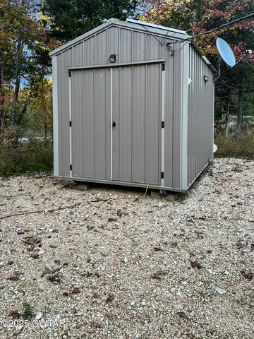 a view of wooden house with backyard and backyard