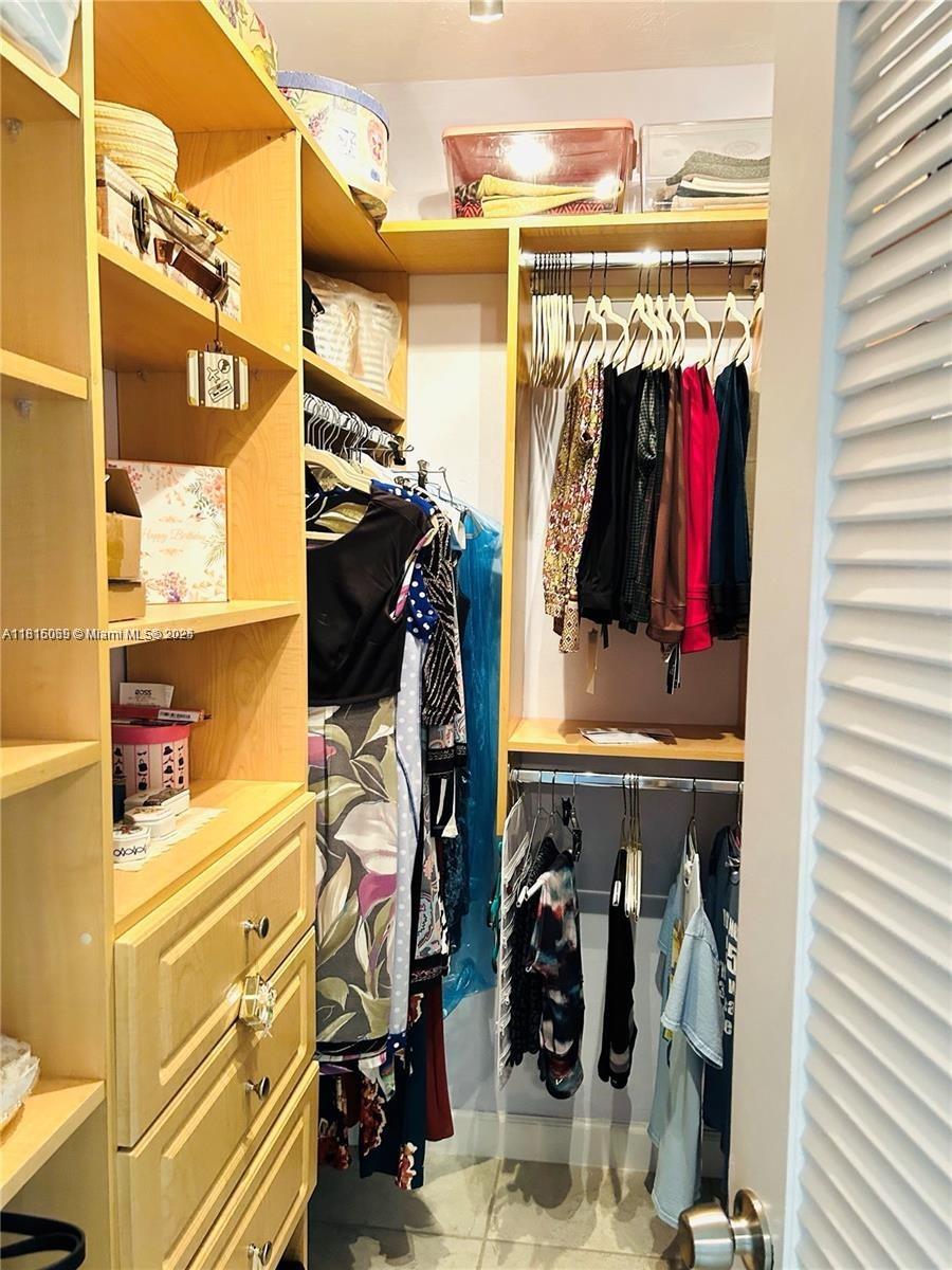 Corinthian Condominiums Miami Beach, FL 33140 - Photo 11 of 19 a view of walk in closet with clothes and shoes